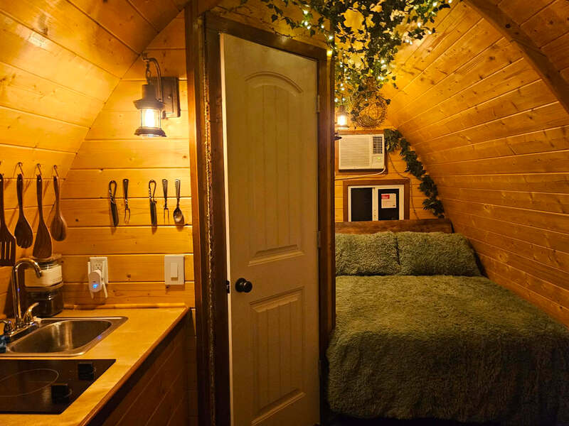 Bed with string lights inside The Little Shire