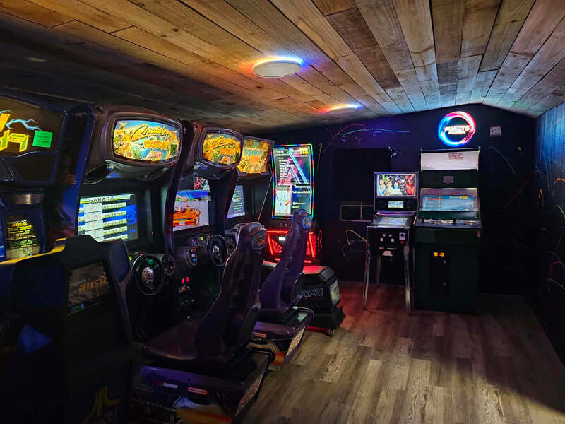 Row of racing arcade cabinets with bucket seats in the Highland Hideaways arcade