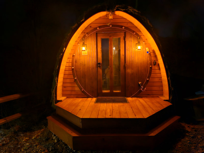 The Little Shire round hobbit door lit up at night