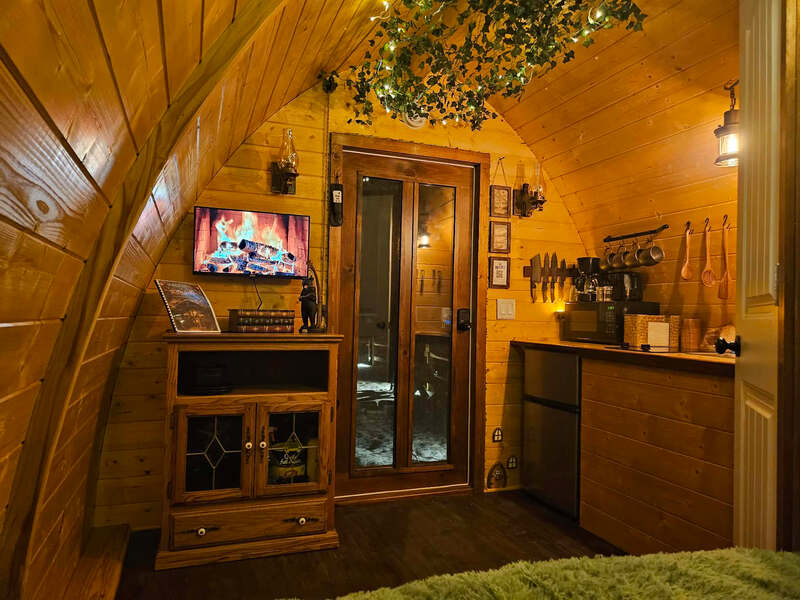 Curved interior of The Little Shire with TV console and kitchenette