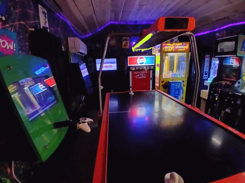 Air hockey table and claw machine inside the Highland Hideaways arcade