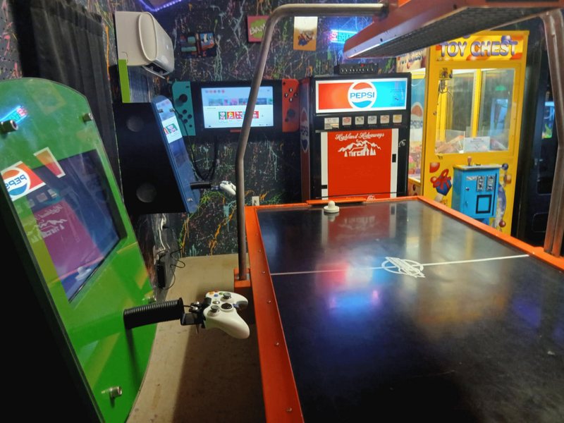 Arcade cabinets and air hockey table inside the Highland Hideaways arcade